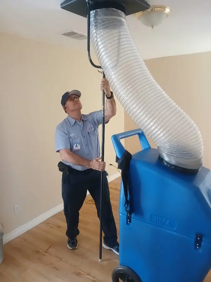 Furnace Tune-Up technician using HEPA equipment in Country Homes