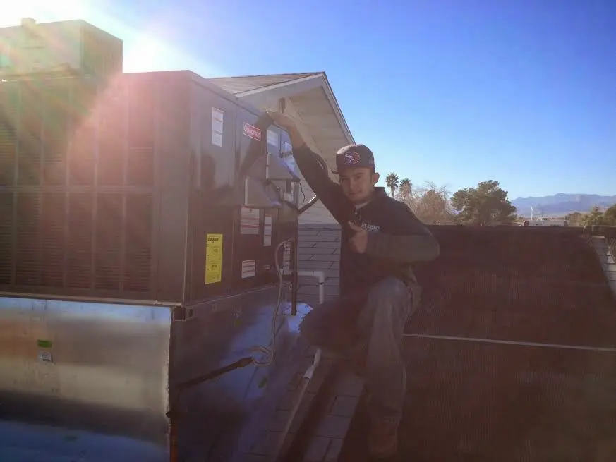 HVAC technician performing Air Duct Repair on a rooftop unit in Country Homes